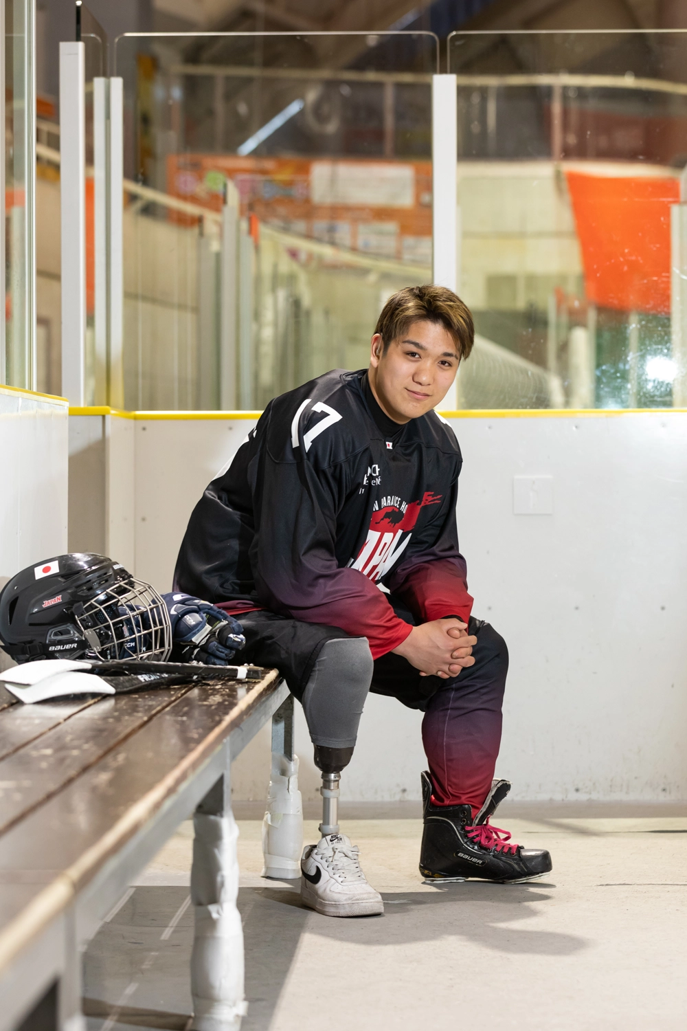 パラアイスホッケーのユニフォームを着用し、ベンチに座る森崎選手の写真